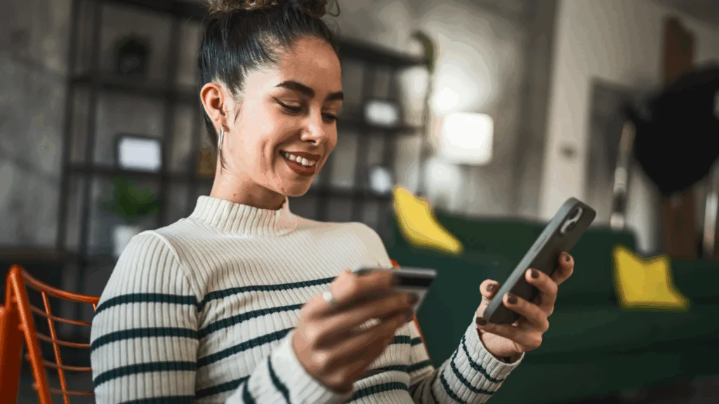 A woman sitting on a couch, focused on her phone while relaxing in a cozy living room setting.