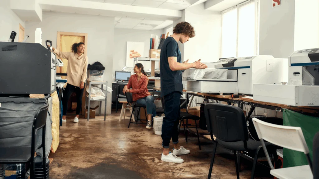 A man and woman collaborate on a computer in a modern office setting, focused on their work.