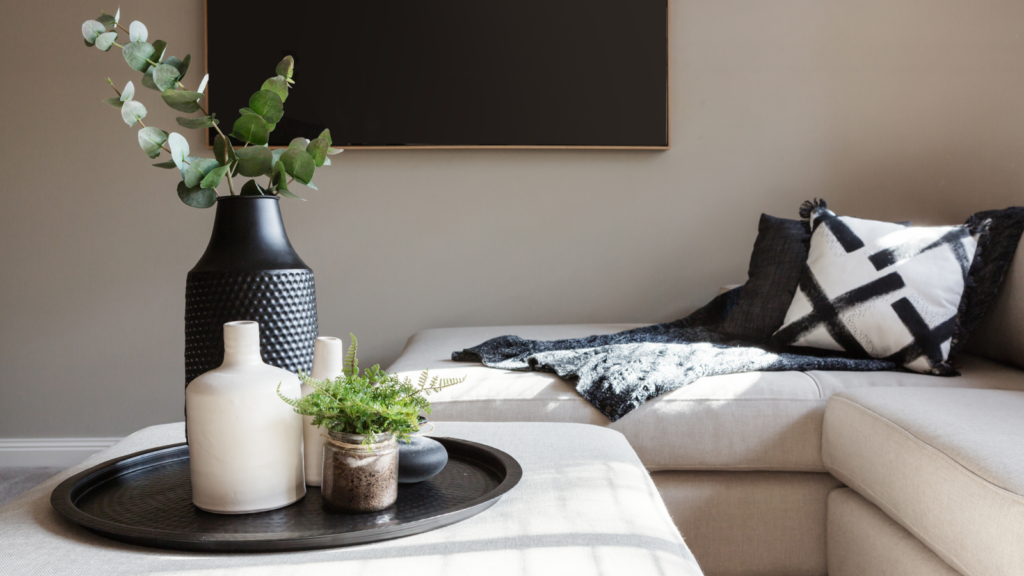 A cozy living room featuring a couch, a coffee table, and decorative vases on display.