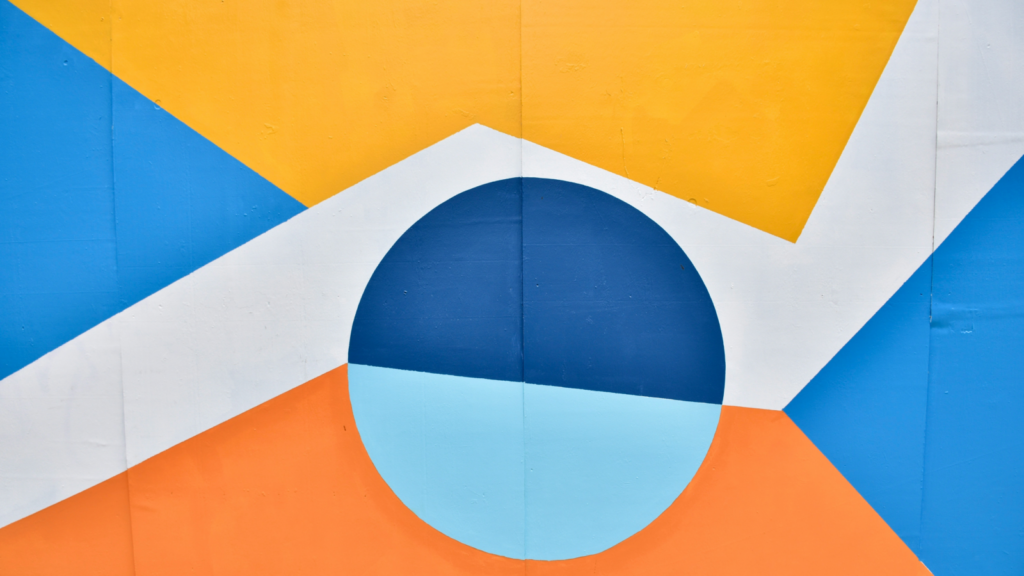 Minimalist geometry A vibrant wall featuring a design in blue, orange, and yellow colors, creating an eye-catching visual display.