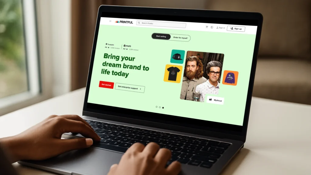 A person is using a laptop with Printful’s homepage on the screen.