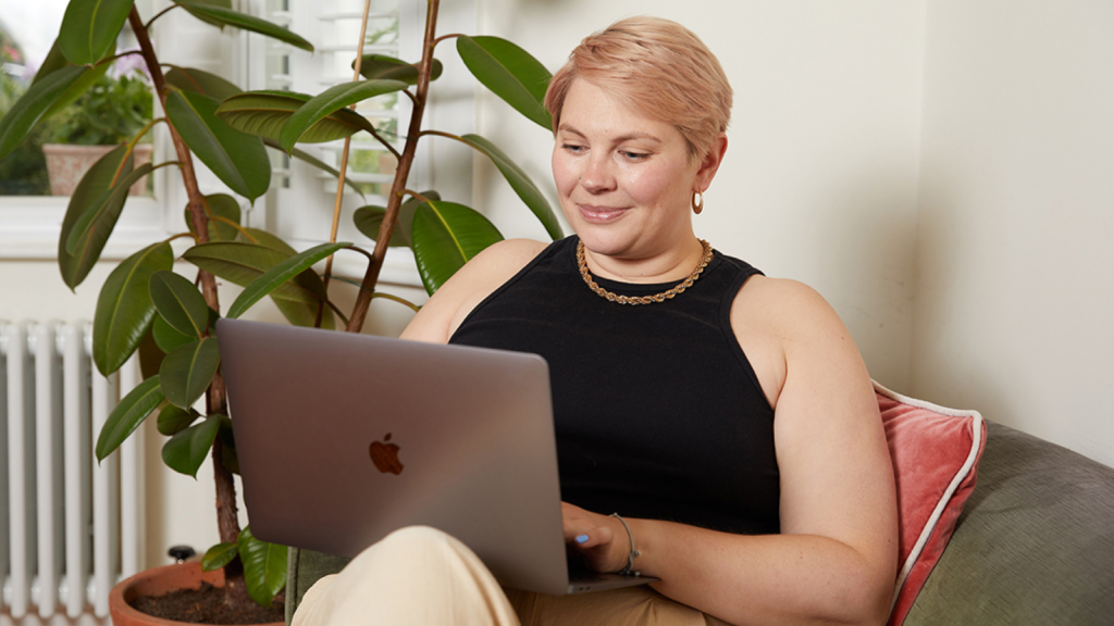 A woman is working on a laptop.
