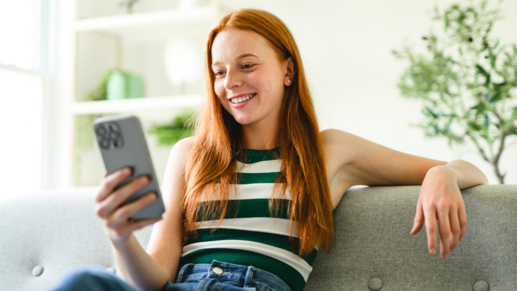 A woman is scrolling on her phone, checking her social media.