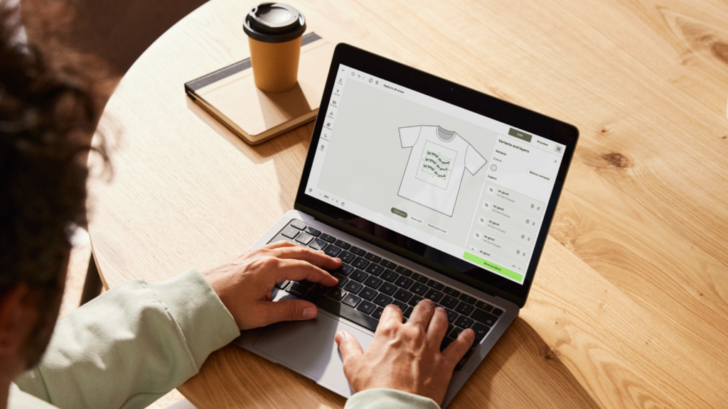 A man using a laptop to design a t-shirt using Printify’s Product Creator.