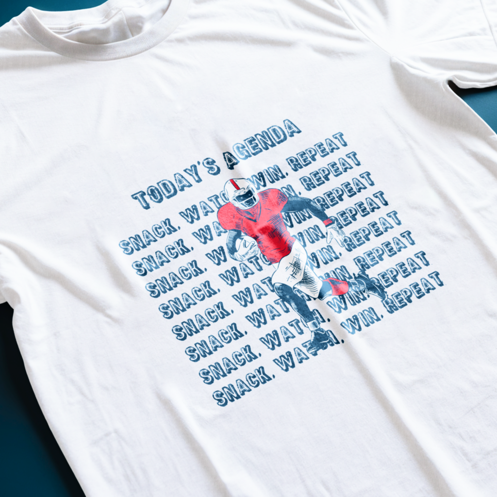 03 Todays agenda White t-shirt with a football player graphic in red and blue. Text says "Today's Agenda: Snack. Watch. Win. Repeat".