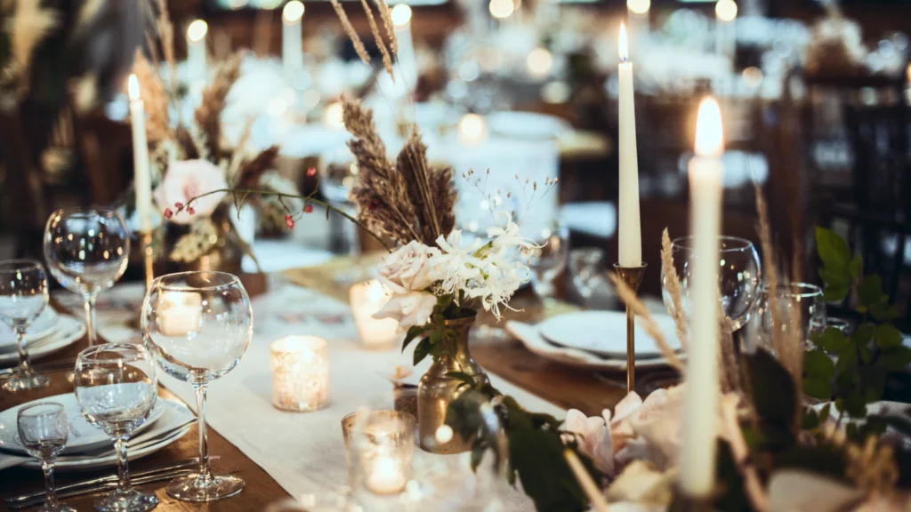A beautifully arranged table featuring lit candles and a bouquet of fresh flowers.