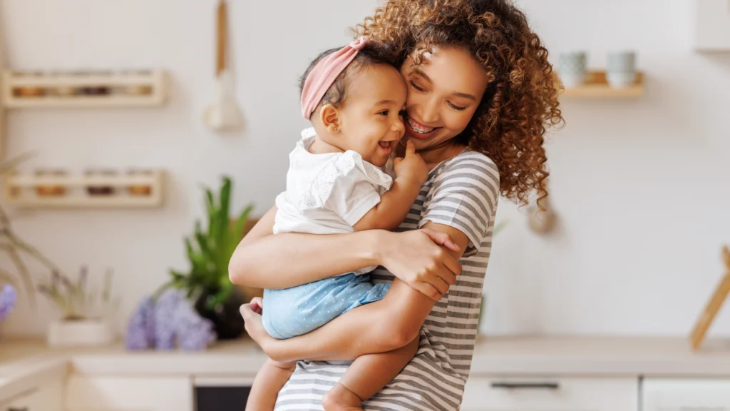 A woman gently cradles a baby in her arms, showcasing a tender moment of care and affection.