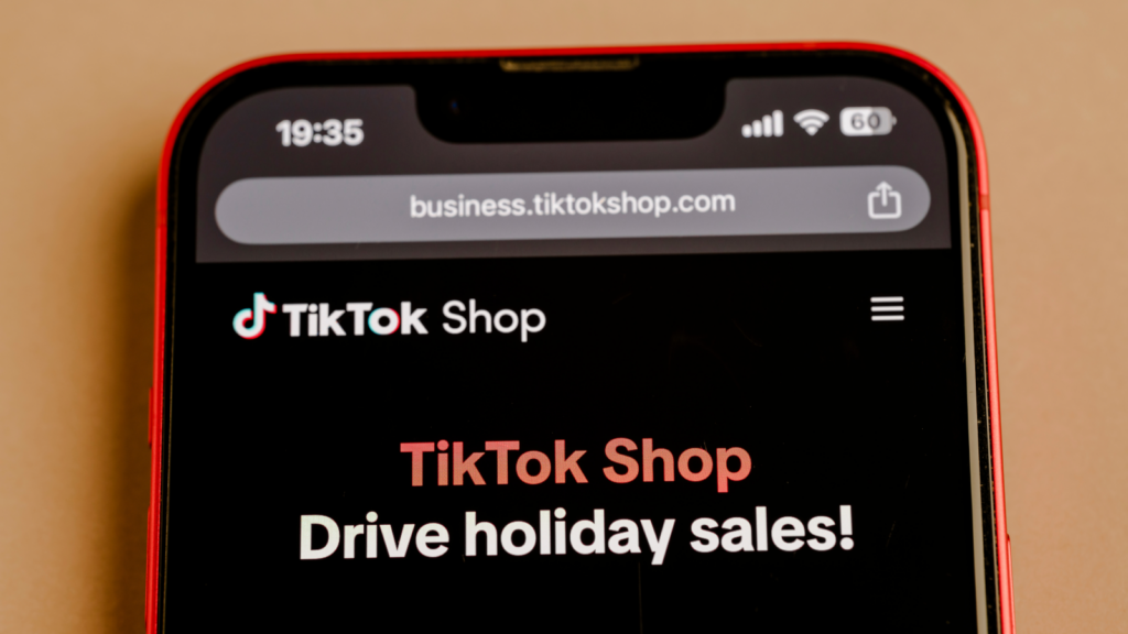 Close-up of a smartphone screen displaying the TikTok Shop webpage, titled "Drive holiday sales!" The tone is inviting and promotional.