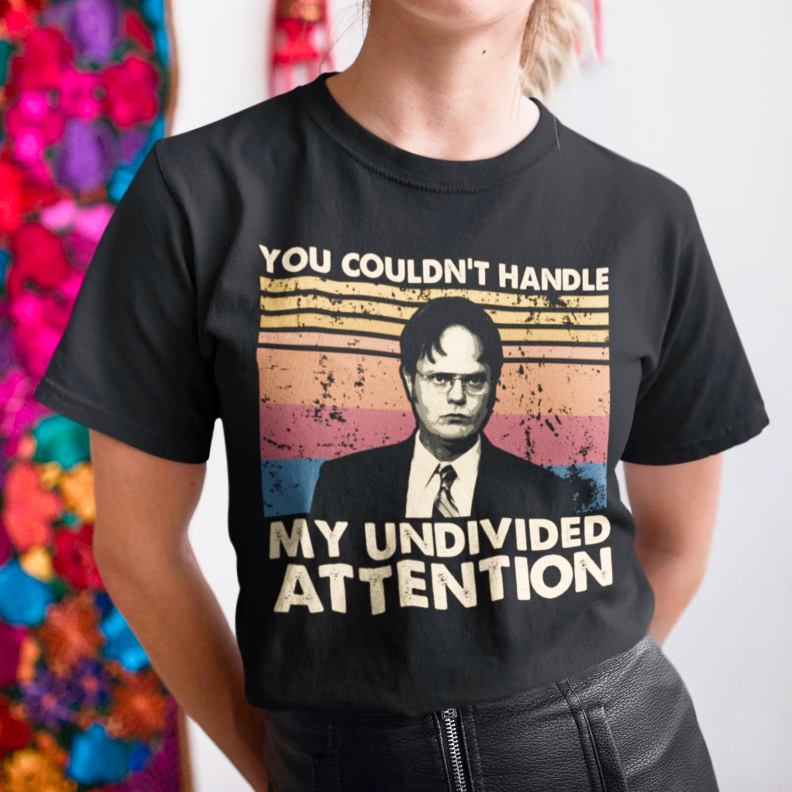 A person wears a black T-shirt featuring a stern-looking character and the text "You Couldn't Handle My Undivided Attention" over vintage stripes.