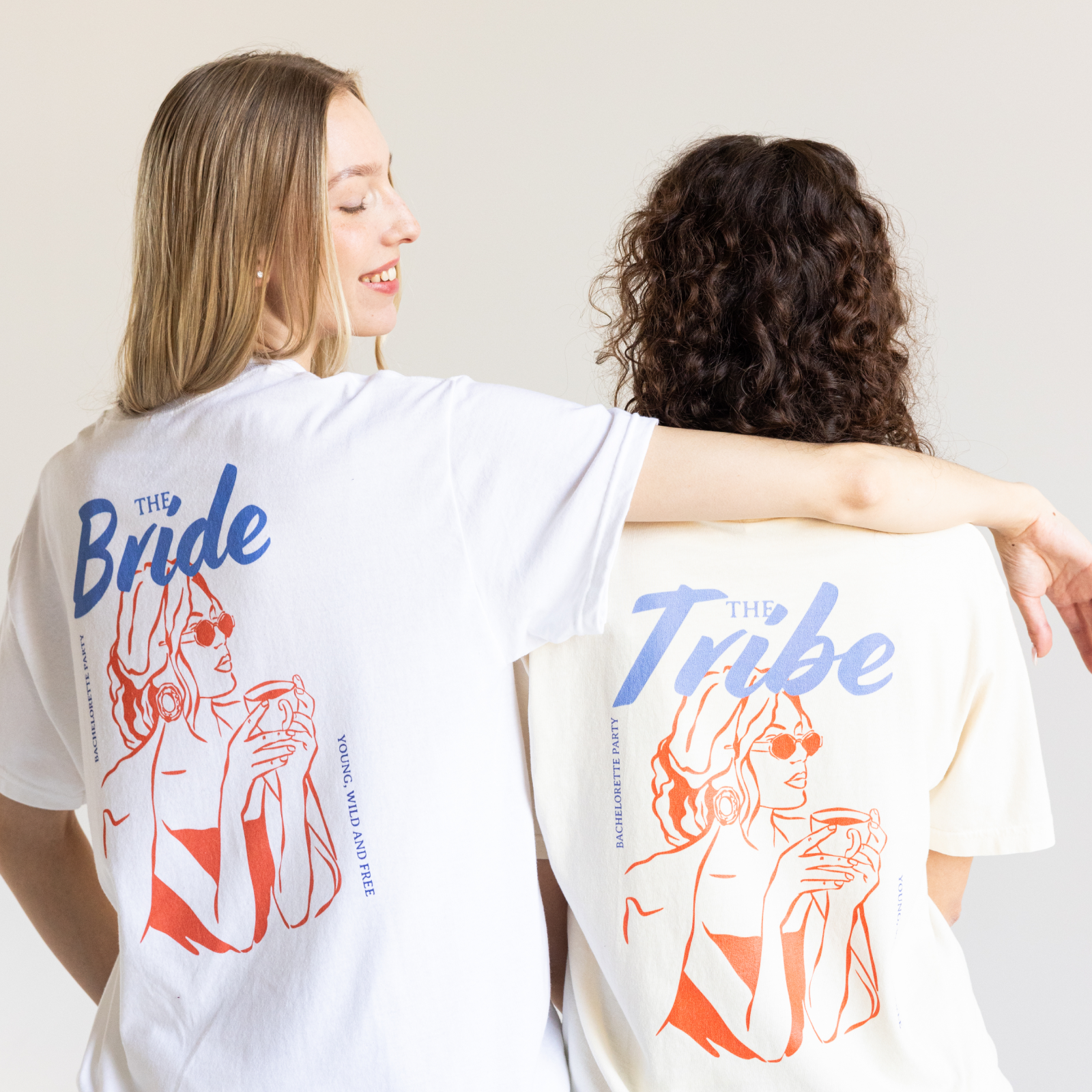 Two women in matching shirts embrace; one labeled "The Bride," the other "The Tribe."