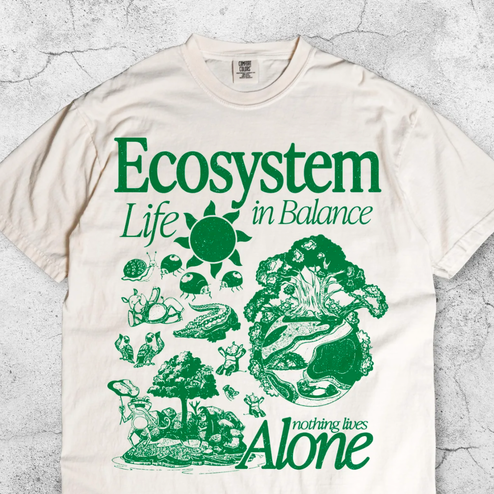 White t-shirt with green illustrations of trees, animals, and a sun.