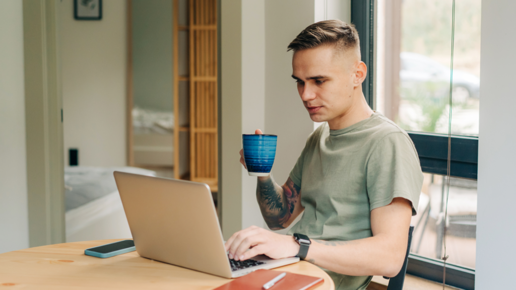 3 Common pricing pitfalls for POD sellers A man is drinking coffee and working on his laptop
