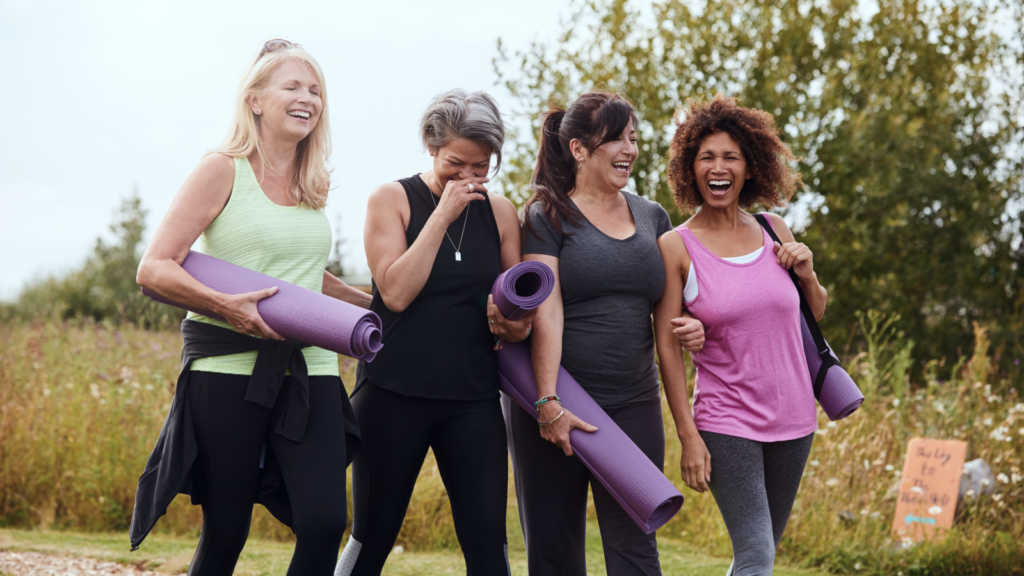 4 8 Workout essentials for summer sales Four women happily walk outdoors with yoga mats, laughing and enjoying each other's company.