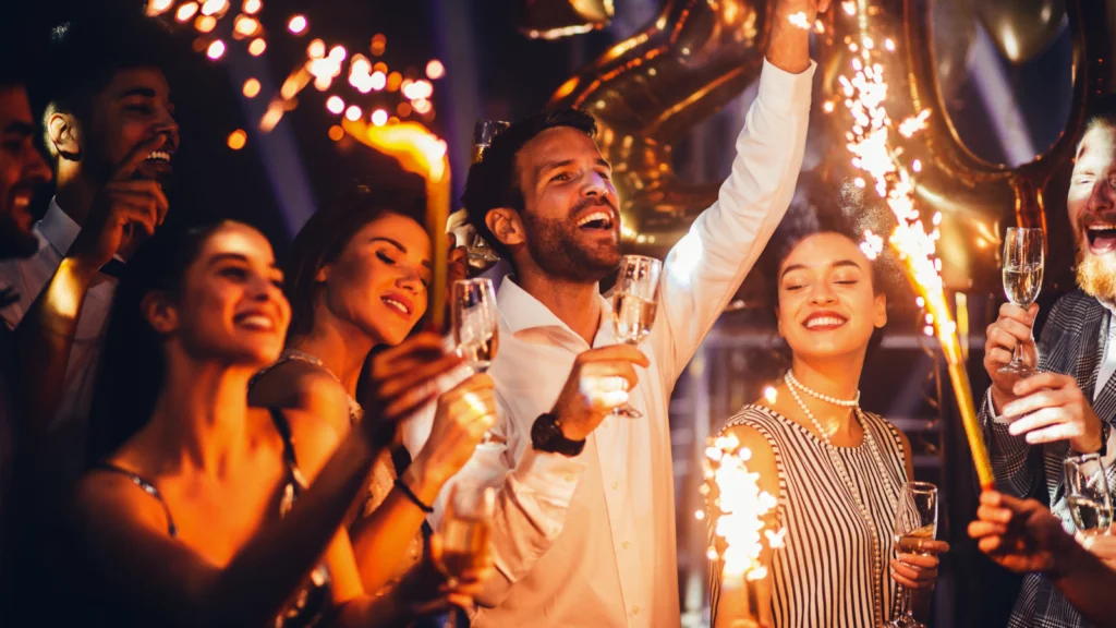 Q1 New beginnings and romantic wins A joyful group of people celebrates with sparklers and champagne at a festive party.