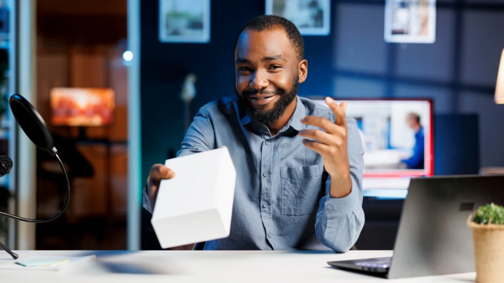 Common advanced TikTok affiliate strategy mistakes A smiling man holds a white box during a product presentation recording in a film studio.