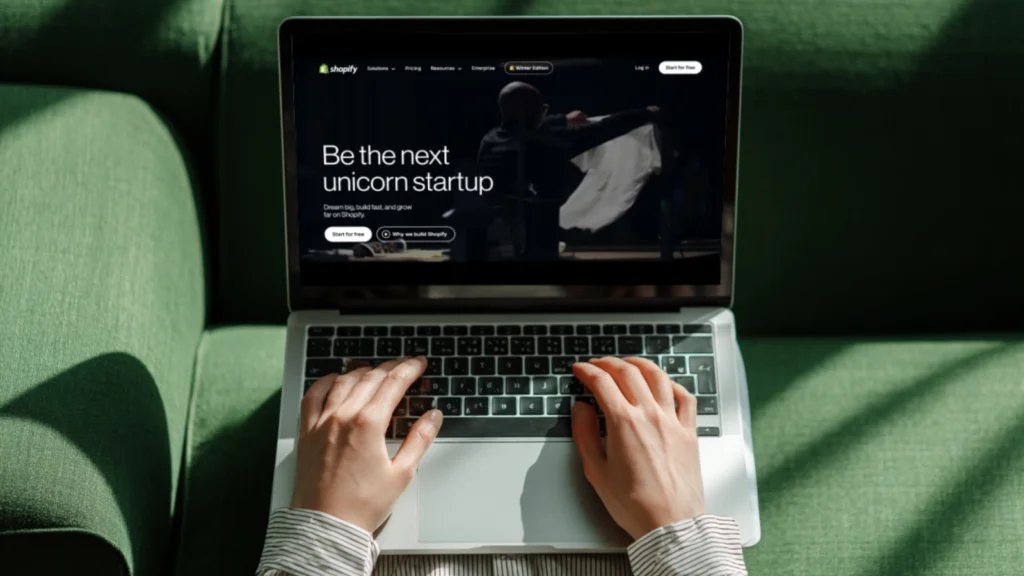 Set up your Shopify store A person is using a laptop with Shopify’s homepage on the screen.