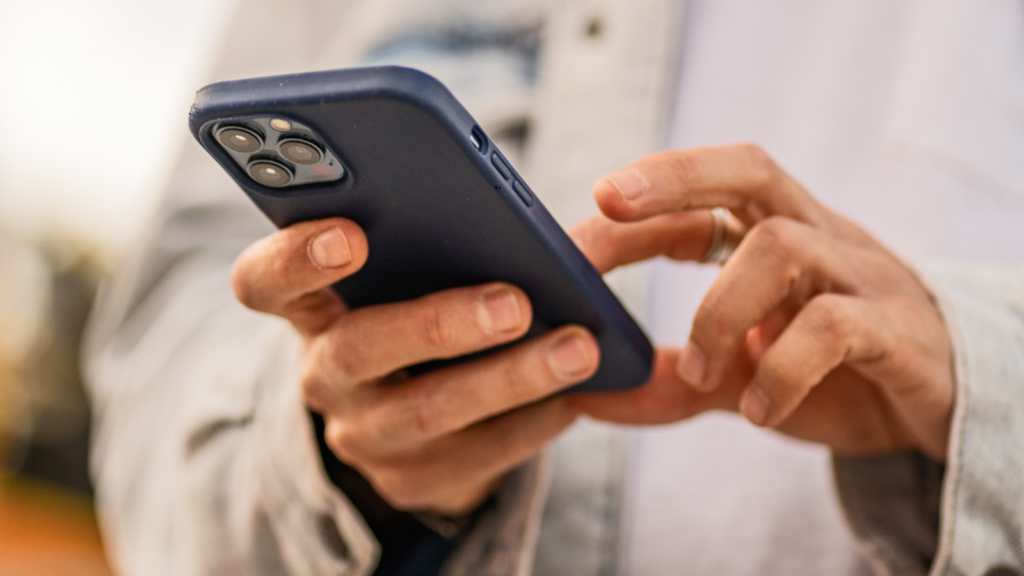 04 Tips to get your TikTok Shop Ads to sell A close-up shot of a person holding a blue smartphone.