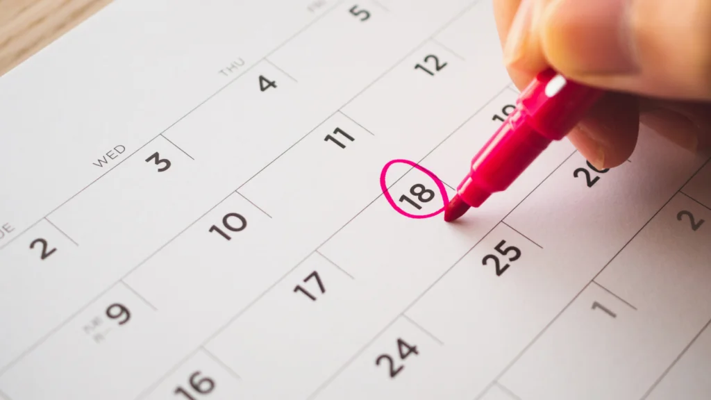 A person is marking the date on the calendar
